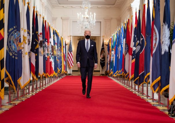 how do you rate biden's first 100 days? // biden walking down a hall with a mask // PRESIDENT JOE BIDEN BEFORE DELIVERING COVID-19 REMARKS ON MARCH 11, 2021. OFFICIAL WHITE HOUSE PHOTO BY ADAM SCHULTZ