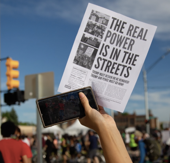 Radical keyword / a sign at a protest is held high / A PROTESTOR IS CAPTURED IN INSIDE SOUTHWEST DETROIT'S FILM, SOLIDARITY.