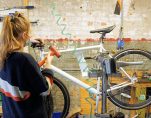 JAI WHITWORTH, MANAGER OF THE HUB AND BACK ALLEY BIKES, REPAIRS A BIKE