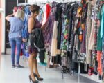 CUSTOMERS LOOKING THROUGH CLOTHING RACKS, PHOTO THE SALVATION ARMY/NINA SCARPELLI