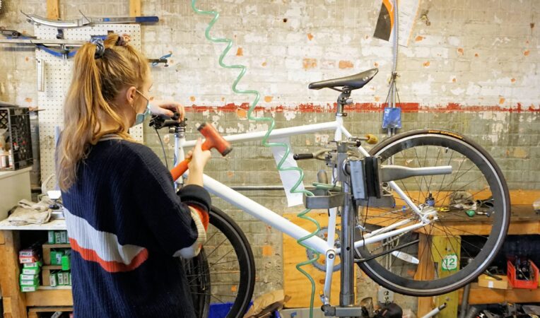 JAI WHITWORTH, MANAGER OF THE HUB AND BACK ALLEY BIKES, REPAIRS A BIKE