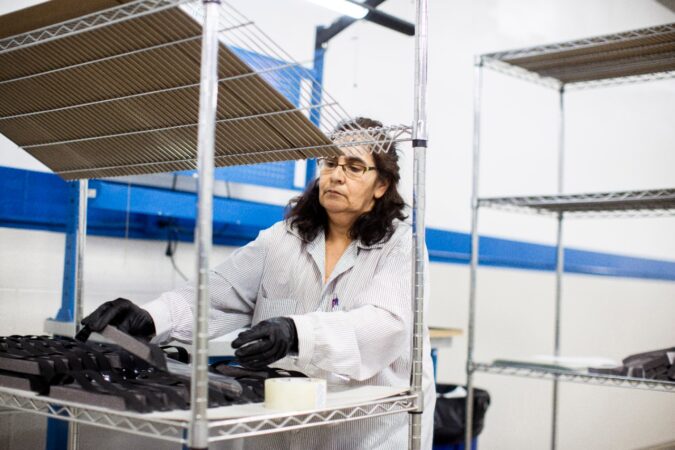 OPERATORS AND ASSEMBLERS ASSEMBLE MEDICAL FACE SHIELDS. PHOTO FORD