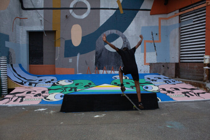 skate park A younger skater lands a flip in front of a mural in the Skate Alley.